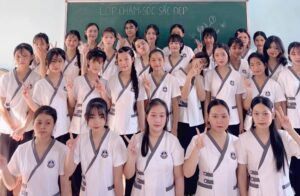 Hình ảnh tập thể lớp học ngành Chăm sóc sắc đẹp tại Trường Trung cấp Nguyễn Tất Thành với đồng phục chuyên ngành, thể hiện môi trường học tập thân thiện, năng động và chuyên nghiệp, nơi học sinh được đào tạo bài bản và rèn luyện tay nghề vững chắc.