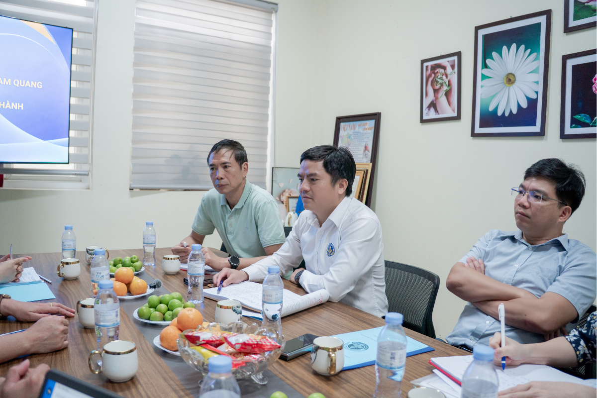 Bức ảnh ghi lại phía bàn làm việc của Trường Trung cấp Nguyễn Tất Thành với sự hiện diện của Thầy Hiệu trưởng Lê Văn Nguyên, Thầy Phó Hiệu trưởng Hà Kiên Cường cùng các thầy cô đại diện lãnh đạo phòng ban. Các thành viên mặc trang phục lịch sự, chỉnh tề, thể hiện phong thái chuyên nghiệp và tinh thần hiếu khách trong suốt buổi thảo luận.