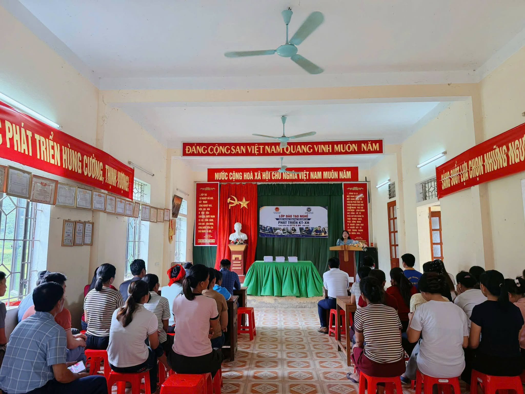 Bức ảnh góc rộng này truyền tải không khí trang nghiêm và sự quan tâm lớn của cộng đồng. Có thể nhìn thấy rõ các vị đại biểu ngồi ở hàng ghế đầu và hàng trăm học viên, trong đó nhiều người mặc trang phục dân tộc, đang chăm chú theo dõi lễ khai giảng.